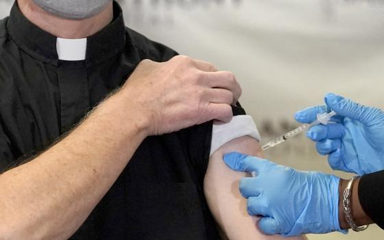 In this Wednesday, Dec. 23, 2020 file photo, a Catholic pastor receives the first of the two Pfizer-BioNTech COVID-19 vaccinations at a hospital in Chicago. In a growing consensus, religious leaders at the forefront of the anti-abortion movement in the Un