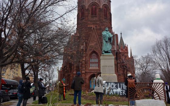 An interfaith group of religious leaders prays outside of Luther Place Memorial Church on Jan 6 in Washington. (RNS/Jack Jenkins)