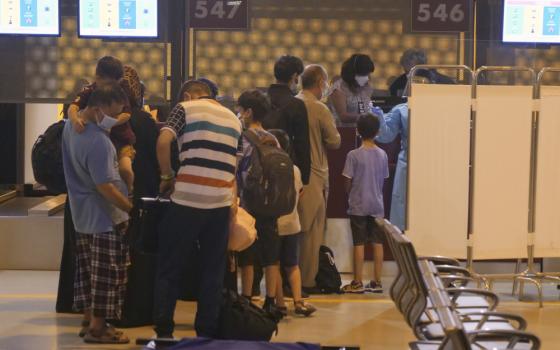 Evacuees from Afghanistan queue in line after arriving at Rome's Leonardo da Vinci international airport in Fiumicino Aug. 24. (AP/Paolo Santalucia)