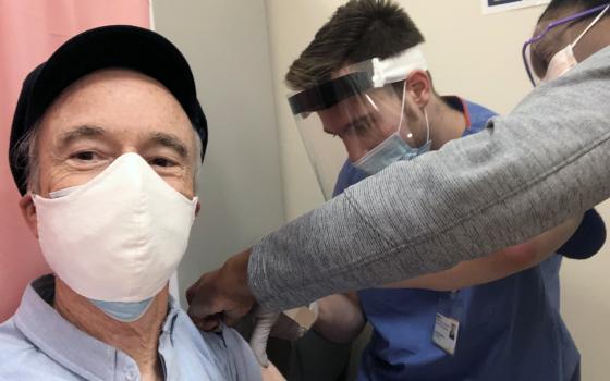 The Rev. Tom Reese, left, receives a COVID-19 vaccine from Dr. Michael Markel, center, and nurse Dia Hannah at Georgetown University Hospital, Medstar Health, Thursday, January 21, 2021. (RNS photo by Tom Reese)