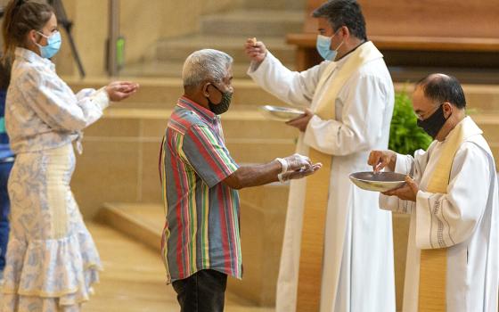 The faithful wear masks and some wear gloves as they receive Communion at the first English Mass with faithful present at the Cathedral of Our Lady of the Angels in downtown Los Angeles, June 7, 2020. (AP)