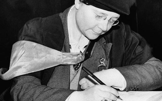 Dorothy L. Sayers signs a visitors' book Feb. 6, 1942, at St. Martin-in-the-Fields church in London, where she addressed the congregation at a lunchtime service. (AP Photo)