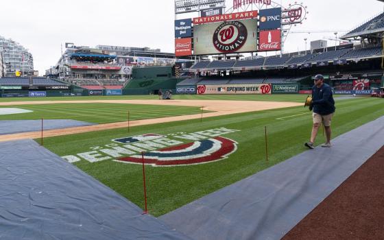 A member of the grounds crew ropes off the on-field logo before baseball workouts at Nationals Park, April 6, in Washington. 