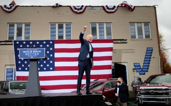 Democratic presidential nominee Joe Biden raises his arm during a drive-in campaign event in Toledo, Ohio, Oct. 12. (CNS//Reuters/Rebecca Cook)