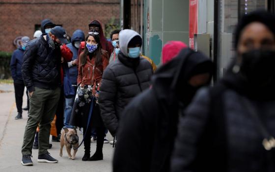 U.S. Rep. Alexandria Ocasio-Cortez, glasses on head, stands in line to vote in the Bronx borough of New York City Oct. 25. (CNS/Reuters/Andrew Kelly)