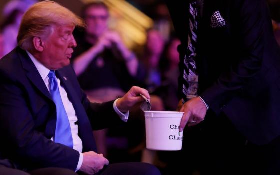 President Donald Trump donates money during a worship service at the International Church of Las Vegas in Las Vegas Oct. 18. (CNS/Reuters/Carlos Barria)