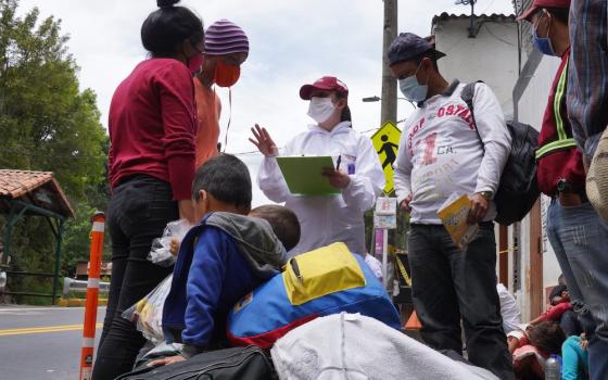 Humanitarian worker Angie Rincon speaks with Venezuelan migrants in early October 2020, at the entrance to Pamplona, Colombia. Rincon is leading a project for migrants funded by Caritas France. (CNS/Manuel Rueda)