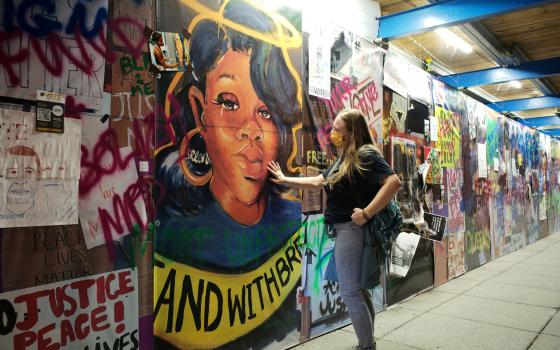 A woman touches a Breonna Taylor mural at Black Lives Matter Plaza in Washington, D.C., Sept. 24. (CNS/Reuters/Cheriss May)