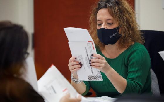 A poll worker reviews a ballot at the Miami-Dade County Elections Department during the presidential election in Miami Nov. 3. (CNS/Reuters/Marco Bello)