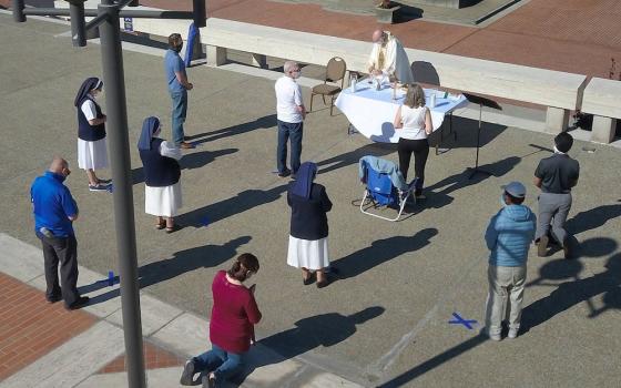 Jesuit Fr. John Piderit, San Francisco's archdiocesan vicar for administration, celebrates Mass simultaneously with three other priests on the feast of the Assumption near the steps of the city's Cathedral of St. Mary of the Assumption Aug. 15. (CNS/San F