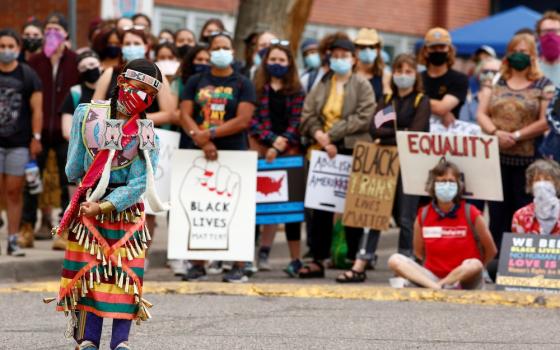 An indigenous girl in Denver dances in traditional dress July 4 during a march that called on Black, indigenous and Latino communities to rise up against oppression. (CNS/Reuters/Kevin Mohatt)