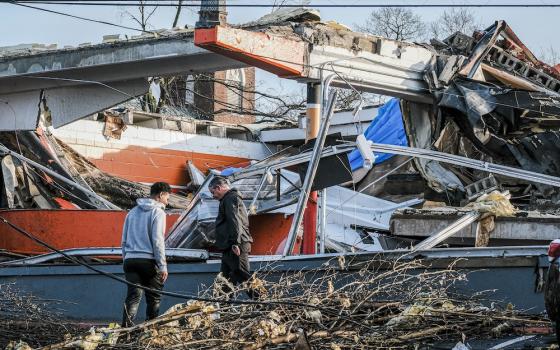 The steeple of the Church of the Assumption is seen in the background as neighbors clean up debris left in a tornado's wake in Nashville, Tennessee, March 3, 2020. (CNS/Tennessee Register/Rick Musacchio)