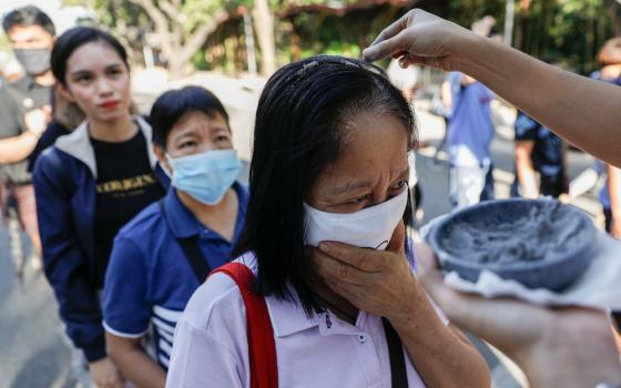 Worshippers wearing protective masks because of COVID-19 receive ashes sprinkled over their heads during Ash Wednesday Mass at the National Shrine of Our Mother of Perpetual Help in Manila, Philippines, Feb. 26, 2020. (CNS/Reuters/Eloisa Lopez)