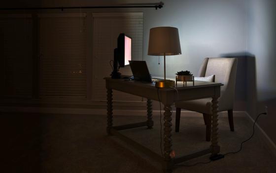 Photograph of a dimly lit room with desk and computer.