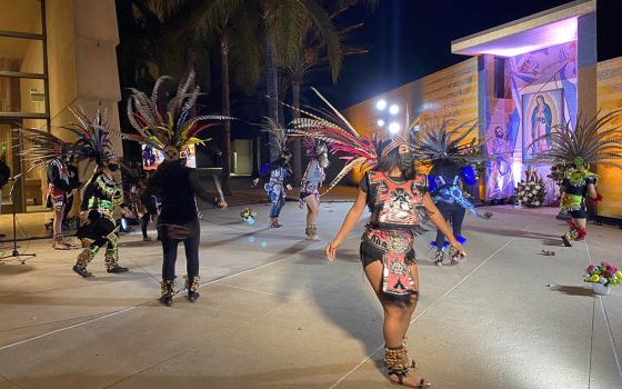 Aztec dancers wearing face masks honor Our Lady of Guadalupe in front of a shrine designed by artist Lalo Garcia in the courtyard of the Cathedral of Our Lady of the Angels in downtown Los Angeles. The performance, part of a Dec. 9 press event, was taped 