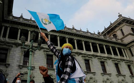 A woman holds up a Guatemalan flag during a protest to demand the resignation of President Alejandro Giammattei in Guatemala City Nov. 22. (CNS/Reuters/Luis Echeverria)