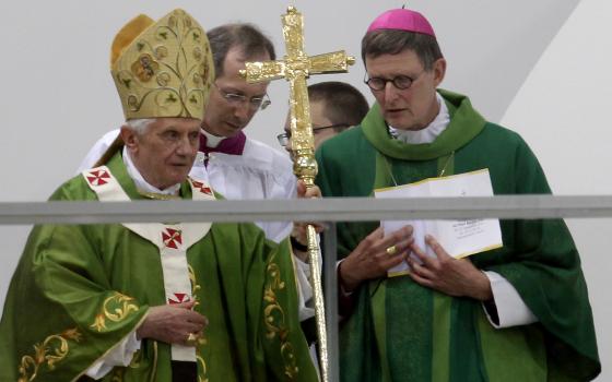 Pope Benedict XVI, left, who retired in 2013, speaking to Berlin's Archbishop Rainer Maria Woelki, right, at a mass at the Olympic Stadium in Berlin, Germany, Jan 6, 2012. (AP Photo/Michael Sohn)