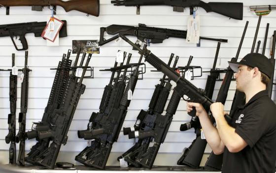 A salesman clears the chamber of an AR-15 in 2016 at a gun store in Provo, Utah. (CNS/Reuters/George Frey)