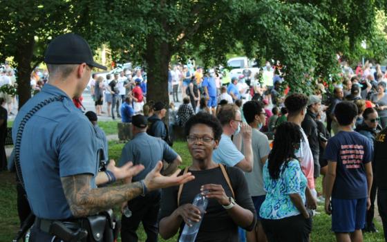 Justine Kenner speaks with a police officer ahead of a "Unity March" in Kansas City, Missouri, June 3. (NCR photo/Brian Roewe)