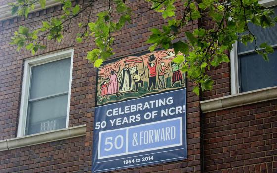 A banner celebrating the National Catholic Reporter's 50th anniversary is seen on the company's headquarters in Kansas City, Missouri. (NCR photo/Teresa Malcolm)