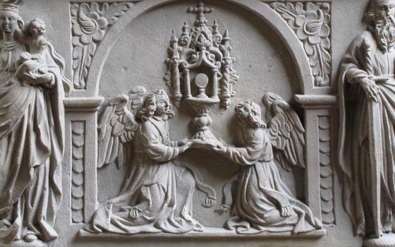 Eucharistic adoration is depicted in relief on a 1624 baptismal font at the Jesuit Church in Molsheim, France. (Wikimedia Commons/©Ralph Hammann)