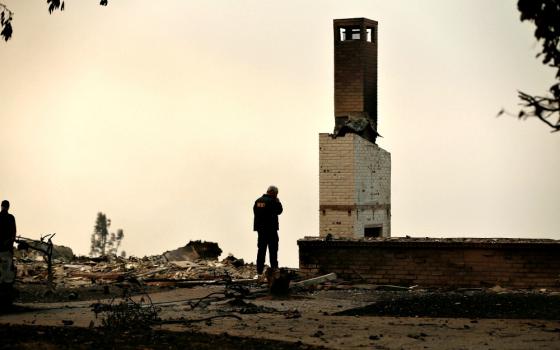 A Butte County Sheriff deputy surveys a home Nov. 11 that was destroyed by the Camp Fire in Paradise, Calif. (CNS/Reuters/Stephen Lam)