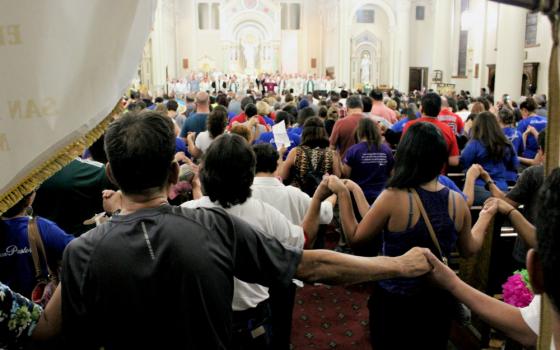 Joining hands, an overflow crowd prays for migrants and refugees during a July 20 evening service at St. Patrick Cathedral in El Paso, Texas. (MVO Photography/Lulu Olvera)