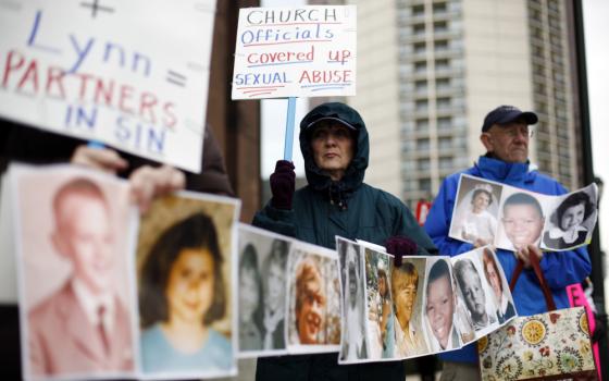 Catherine Coleman Murphy, center, and Jack Wintermyer, right, protest along with others outside Cathedral Basilica of Sts. Peter and Paul before an Ash Wednesday Mass in Philadelphia on March 9, 2011. (AP/Matt Rourke)