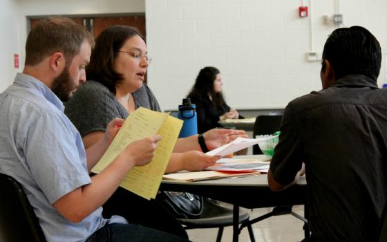 Michelle Sardone, second from left, and another staff volunteer from Catholic Legal Immigration Network assist at a screening for those with Deferred Action for Childhood Arrivals status Sept. 11 at St. John Neumann Catholic Church in Reston, Virginia.