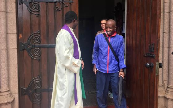 A parishioner talks with Fr. Norbert Munekani after Mass at Holy Trinity Catholic Church in Johannesburg, before the South African government imposed a lockdown to combat the coronavirus outbreak. (Patrick Egwu)