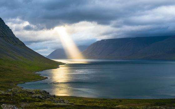 Sunbeam coming down from clouds into a body of water (Unsplash/Davide Cantelli)