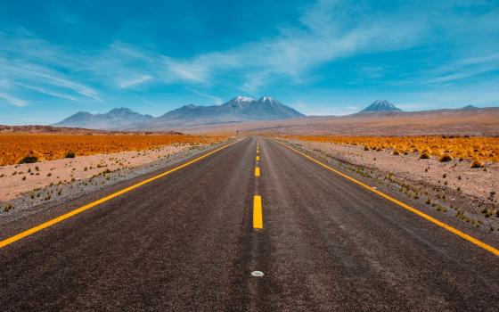 Image of a road in the desert facing mountains (Unsplash/Diego Jimenez)