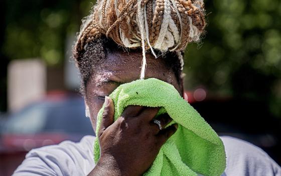 Nicole Brown wipes sweat from her face while setting up her beverage stand near the National Mall July 22, during a heat wave in Washington, D.C. (AP/Nathan Howard)