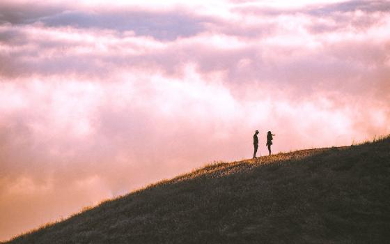 Couple on a hillside (Unsplash/Casey Horner)