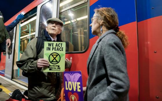 Phil Kingston, 83, a former parole officer, protests climate change after super-gluing himself to the side of a train on the platform at London's Shadwell Station Oct. 17. (Courtesy of Extinction Rebellion/ Vladimir Morozov)