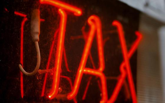 Neon tax sign (Unsplash/Jon Tyson)