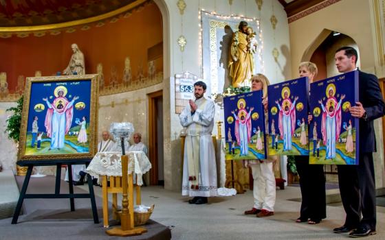 Members of the Catholic Community of Flint in Michigan present an icon of Mother, Mary of Flint at St. Mary Church, along with replicas to be placed in the three other churches of the community on Mother's Day, May 13. (Gary Pearce)