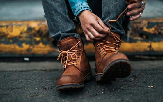 Putting on boots (Unsplash/Nathan Dumlao)