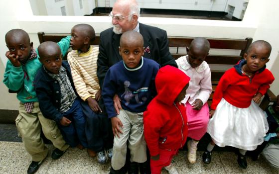 Jesuit Fr. Angelo D'Agostino, founder of Nyumbani children's home for HIV/AIDS orphans sits outside a courtroom in Nairobi, Kenya, in January 2004. (Newscom/Reuters/Antony Njuguna)