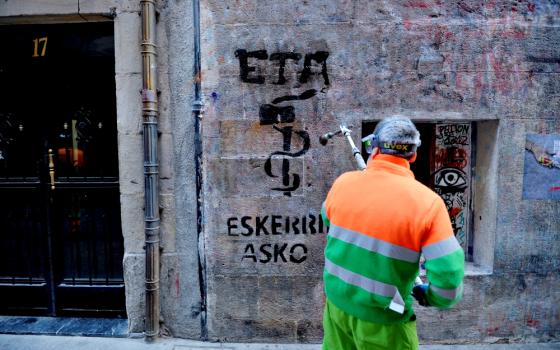 A municipal worker in Bilbao, Spain, on May 5 removes graffiti reading, "ETA, thanks," two days after the militant Basque separatist group ETA announced it had completely disbanded. (Newscom/Reuters/Vincent West)