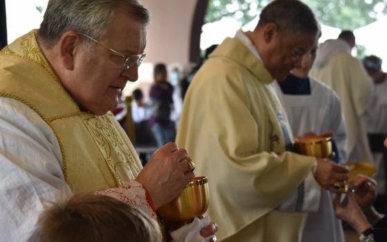 Chicago Auxiliary Bishop Joseph Perry and U.S. Cardinal Raymond Burke distribute Communion during Mass July 9 at the National Blue Army Shrine of Our Lady of Fatima in Asbury, New Jersey. (CNS/World Apostolate of Fatima, USA)