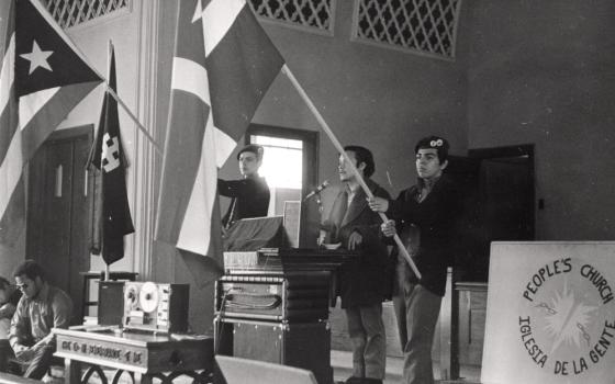 Young Lords members hold flags inside the Armitage Methodist Church in March 1970, commemorating the Masacre de Ponce. (Photo © Carlos Flores)