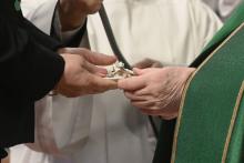 Pope Francis gives a crucifix to a layperson he installed as a catechist Jan. 23 during a Mass in St. Peter's Basilica at the Vatican. The Dicastery for Laity, the Family and Life is sponsoring a conference aimed at promoting the "co-responsibility" of laypeople and clergy for the life of the church and its mission in the world. (CNS/Vatican Media)