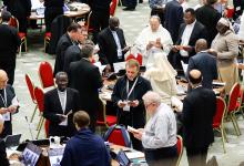 Members of the assembly of the Synod of Bishops pray before a working session in the Vatican's Paul VI Audience Hall Oct. 26. (CNS/Lola Gomez)