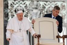 Pope Francis, walking with a cane, reaches his chair held by his aide, Sandro Mariotti, as he arrives for his weekly general audience in St. Peter's Square at the Vatican March 20, 2024. (CNS/Lola Gomez)