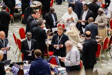 Members of the assembly of the Synod of Bishops pray before a working session in the Vatican's Paul VI Audience Hall Oct. 26, 2023. (CNS/Lola Gomez)