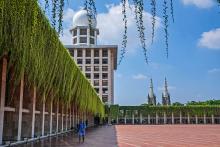 A man walks in the shade at Istiqlal mosque as the spires of the Our Lady of the Assumption Cathedral are seen in the background, in Jakarta, Indonesia, Aug. 9. (AP/Tatan Syuflana)