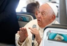 Pope Francis answers a question from a journalist aboard his flight back to Rome Sept. 29, after visiting Luxembourg and Belgium during his 46th international trip. (CNS/Lola Gomez)