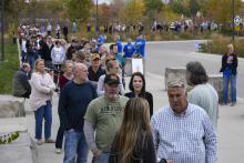 Long line of people on sidewalk.