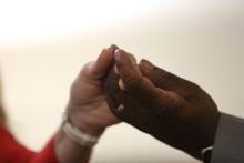 A woman and man join hands during the Our Father during Mass. (CNS/Bob Roller)